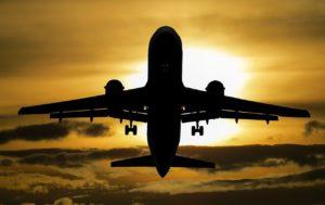 A picture of a JetBlue airplane silhouette in flight at sunset