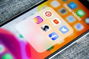 A picture of a phone with multiple social media apps on it.