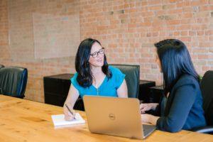 A picture of a business owner openly communicating with a client while sitting at a table.