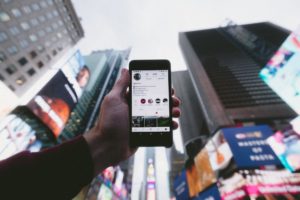 A person holding their phone up and learning what the social media don'ts are